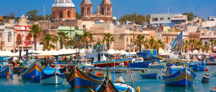Traditional eyed colorful boats Luzzu in the Harbor of Mediterranean fishing village Marsaxlokk, Malta