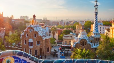 Barcelona city view from Guell Park with colorful mosaic buildings in tourist attraction Park Guell in the morning on sunrise. Barcelona, Spain