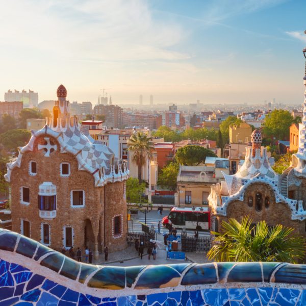 Barcelona city view from Guell Park with colorful mosaic buildings in tourist attraction Park Guell in the morning on sunrise. Barcelona, Spain