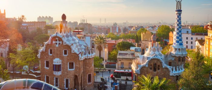 Barcelona city view from Guell Park with colorful mosaic buildings in tourist attraction Park Guell in the morning on sunrise. Barcelona, Spain
